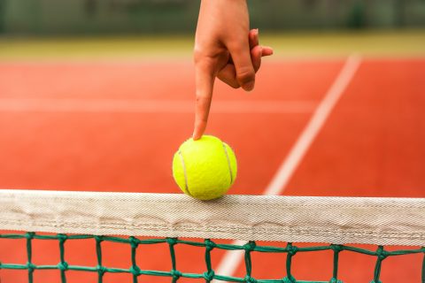finger on tennis ball